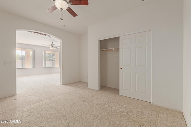 unfurnished bedroom with ceiling fan, a closet, and carpet