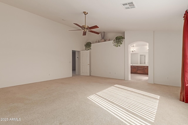 carpeted empty room with high vaulted ceiling and ceiling fan