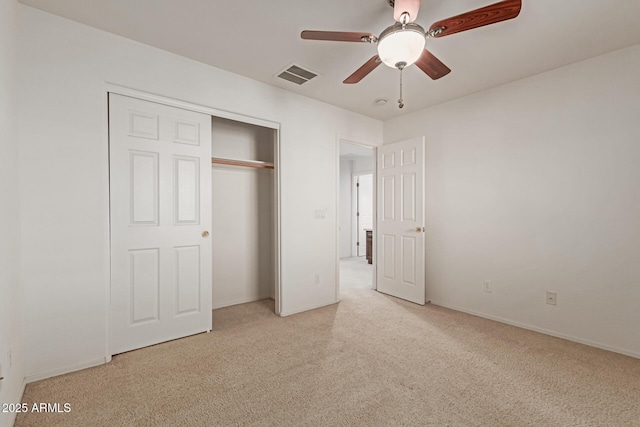 unfurnished bedroom featuring light carpet, ceiling fan, and a closet