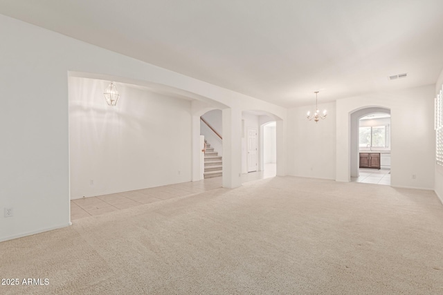 unfurnished living room with light carpet and an inviting chandelier