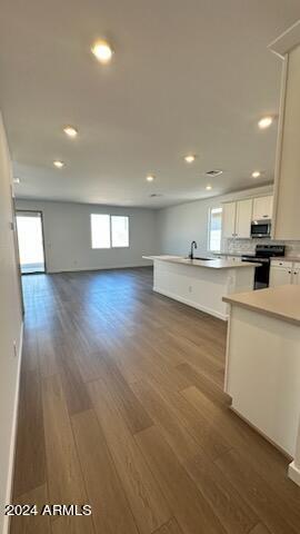 kitchen featuring wood-type flooring, stainless steel appliances, white cabinetry, and sink