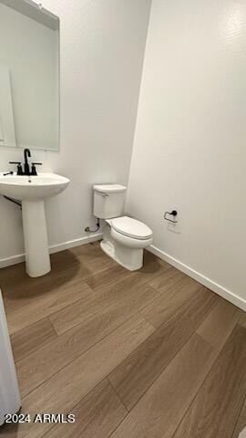 bathroom with toilet and hardwood / wood-style flooring