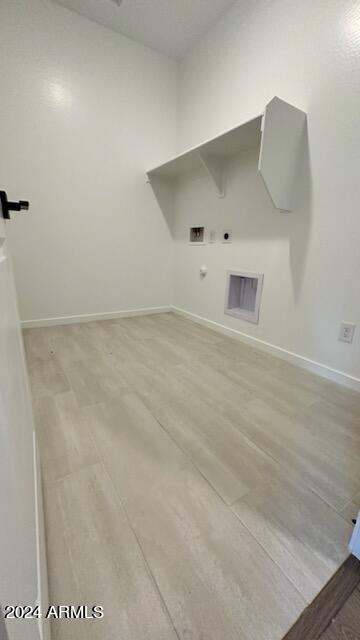 washroom with washer hookup, light hardwood / wood-style flooring, hookup for a gas dryer, and electric dryer hookup