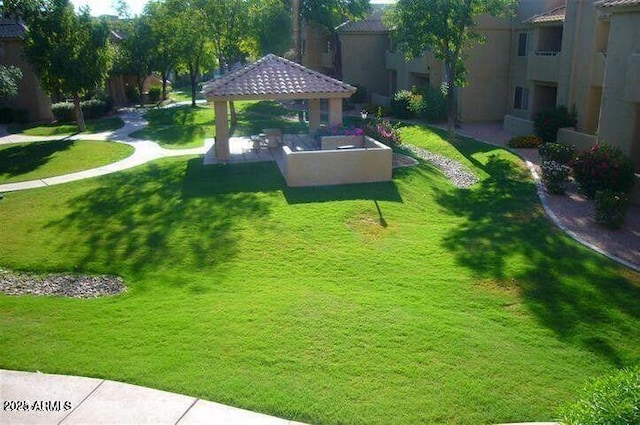 view of property's community with a lawn and a gazebo