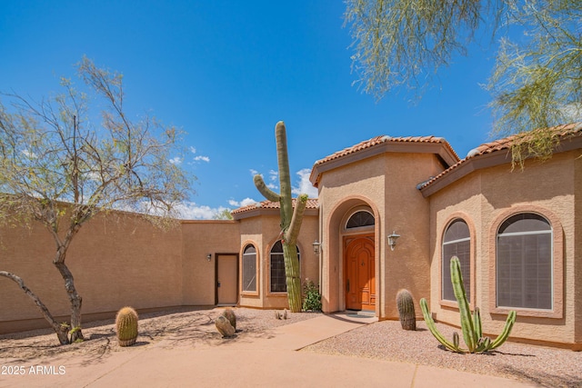 mediterranean / spanish-style home with stucco siding and a tile roof