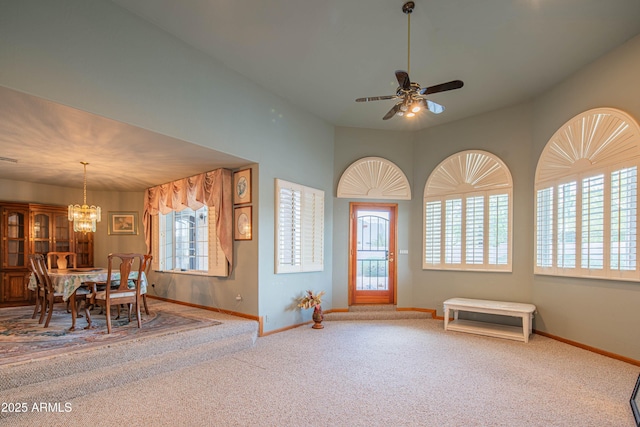 carpeted entryway with baseboards and ceiling fan with notable chandelier