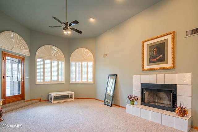 unfurnished living room featuring carpet flooring, a ceiling fan, baseboards, and a fireplace