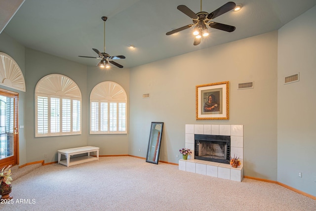 unfurnished living room featuring carpet floors, ceiling fan, a wealth of natural light, and visible vents