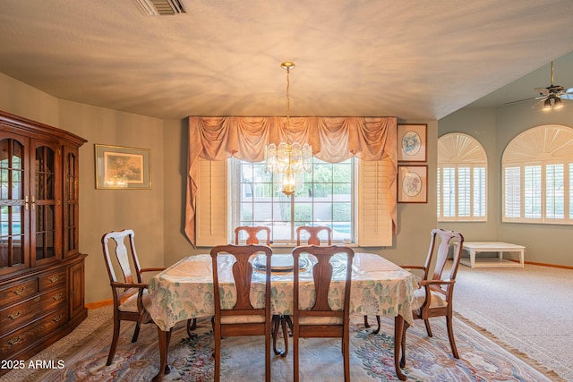 carpeted dining room with baseboards, ceiling fan with notable chandelier, and visible vents