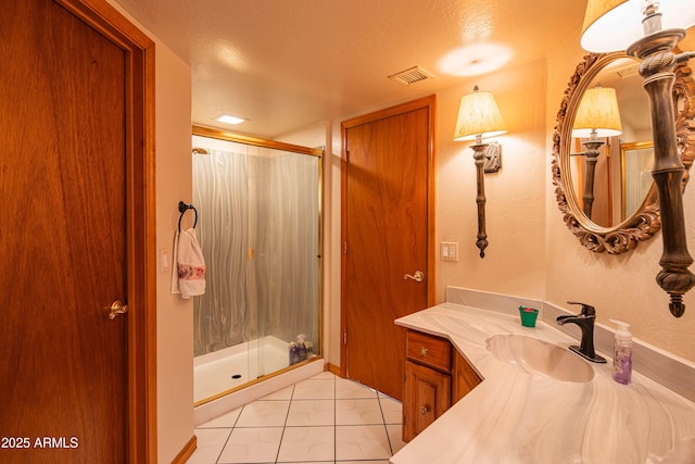 bathroom with vanity, a shower stall, a textured ceiling, and visible vents