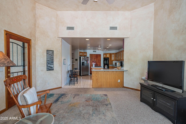 living room featuring a ceiling fan, baseboards, and visible vents