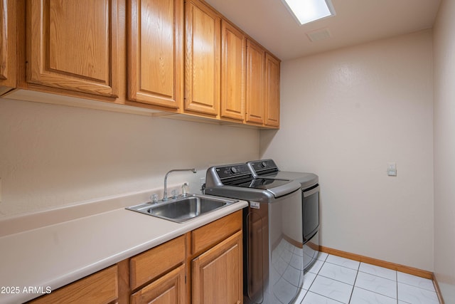 laundry room featuring cabinet space, a sink, baseboards, visible vents, and washing machine and dryer