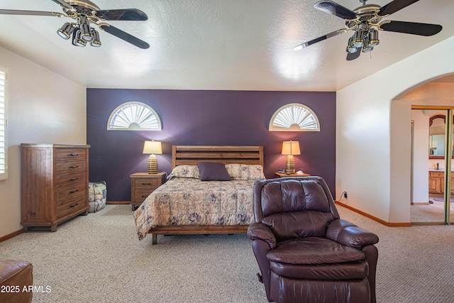 bedroom featuring arched walkways, multiple windows, baseboards, and carpet flooring