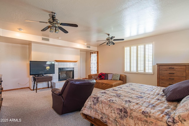 bedroom featuring carpet floors, baseboards, a tile fireplace, and visible vents