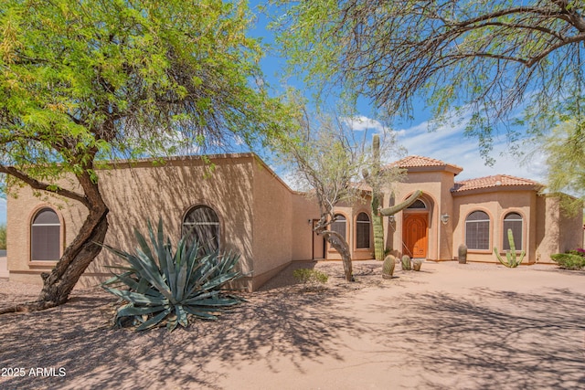view of front of home featuring stucco siding and a tile roof