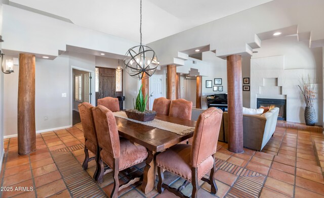 tiled dining space featuring decorative columns and an inviting chandelier