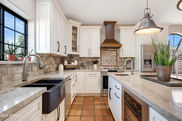 kitchen featuring custom exhaust hood, decorative backsplash, hanging light fixtures, appliances with stainless steel finishes, and white cabinets