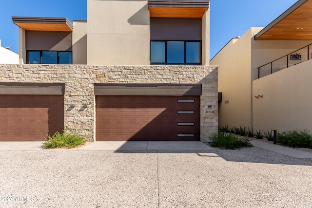 6311 E Phoenician Blvd Unit 18, Scottsdale, AZ 85251 - modern home featuring driveway, stone siding, an attached garage, and stucco siding