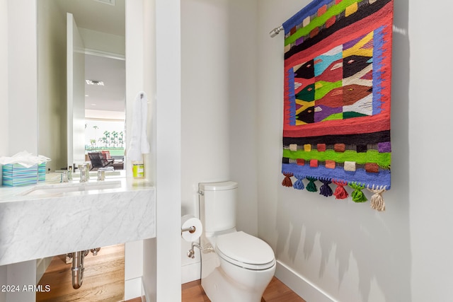 bathroom featuring hardwood / wood-style flooring and toilet