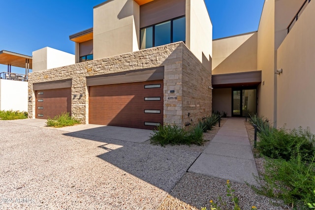 6311 E Phoenician Blvd Unit 18, Scottsdale, AZ 85251 - view of front of house with stone siding, stucco siding, driveway, and a garage