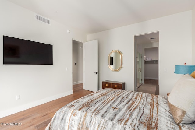 bedroom featuring wood-type flooring, a spacious closet, and a closet