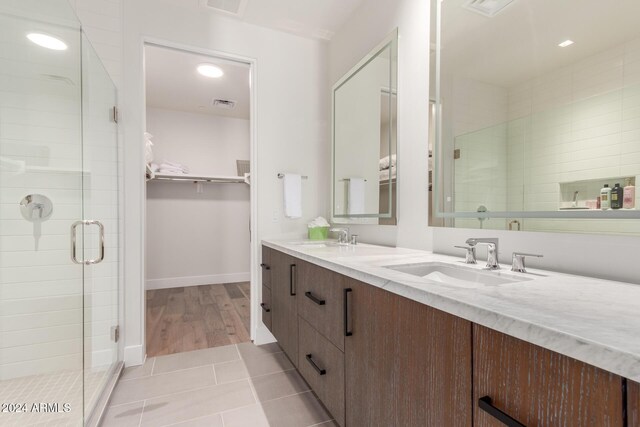 6311 E Phoenician Blvd Unit 18, Scottsdale, AZ 85251 - bathroom with double vanity, a stall shower, a spacious closet, tile patterned floors, and baseboards