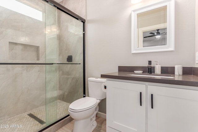 full bathroom featuring vanity, a stall shower, wood finished floors, and toilet