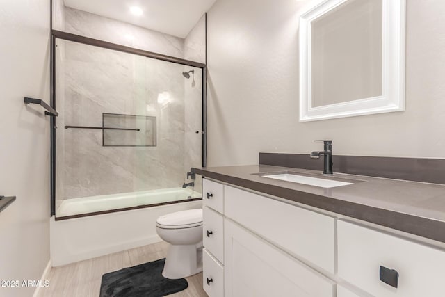 full bathroom featuring vanity, toilet, and bath / shower combo with glass door