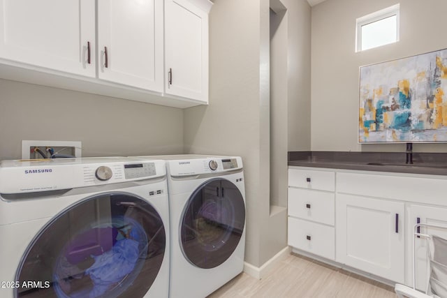 laundry room with cabinet space, a sink, and separate washer and dryer