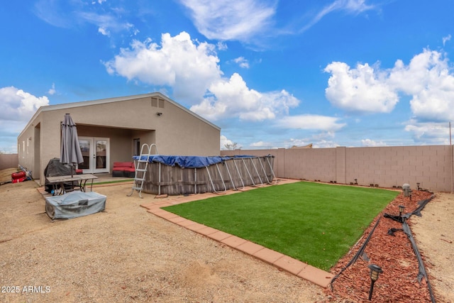 view of yard featuring a fenced in pool, french doors, and a fenced backyard