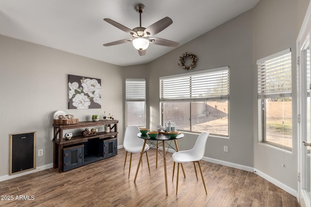 dining room with lofted ceiling, wood finished floors, a ceiling fan, and baseboards