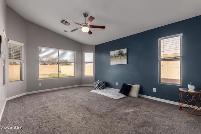 interior space with lofted ceiling, visible vents, a ceiling fan, carpet flooring, and baseboards