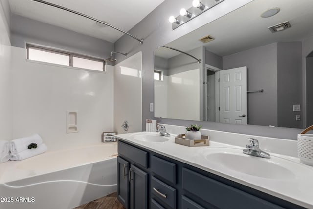 bathroom with shower / bath combination, a sink, visible vents, and double vanity