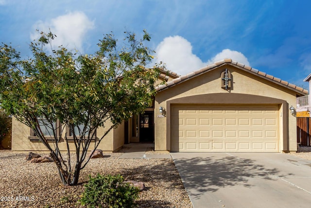 view of front facade featuring a garage, concrete driveway, a tile roof, and stucco siding