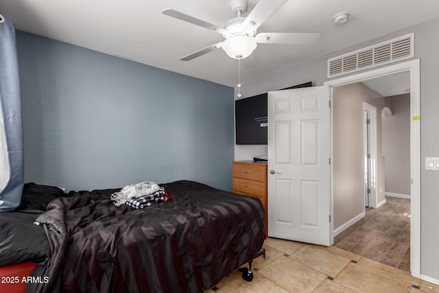 bedroom featuring visible vents, ceiling fan, baseboards, and light tile patterned floors