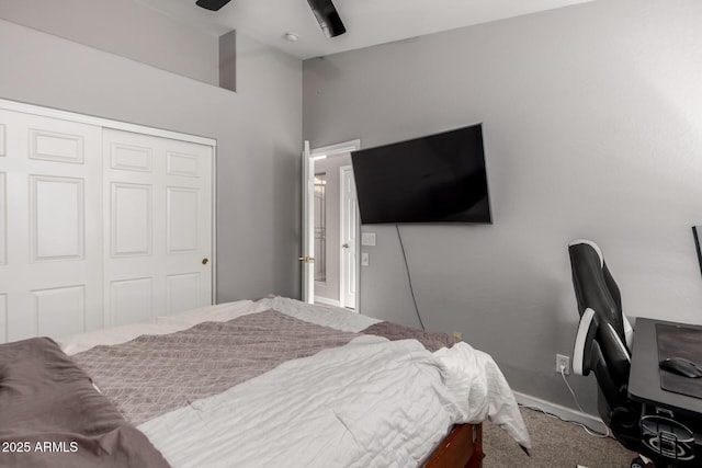 carpeted bedroom featuring a ceiling fan, a closet, and baseboards