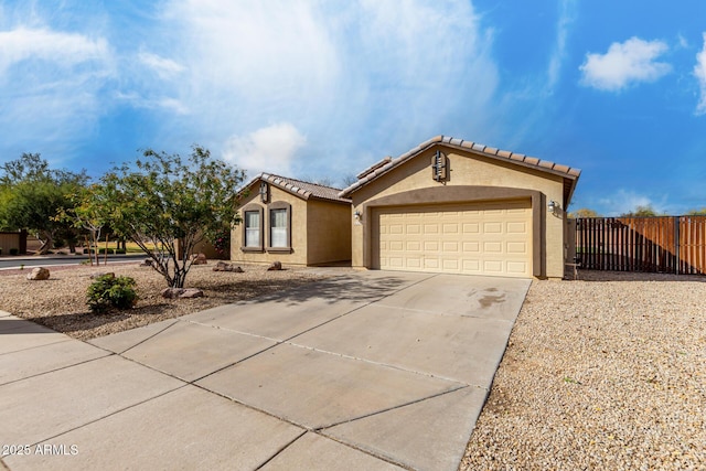 view of front of property with a tile roof, stucco siding, fence, a garage, and driveway