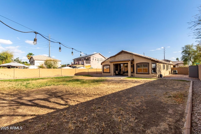 back of house with a patio area, a fenced backyard, and stucco siding