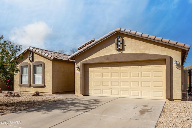 mediterranean / spanish-style house featuring a garage, concrete driveway, a tiled roof, and stucco siding