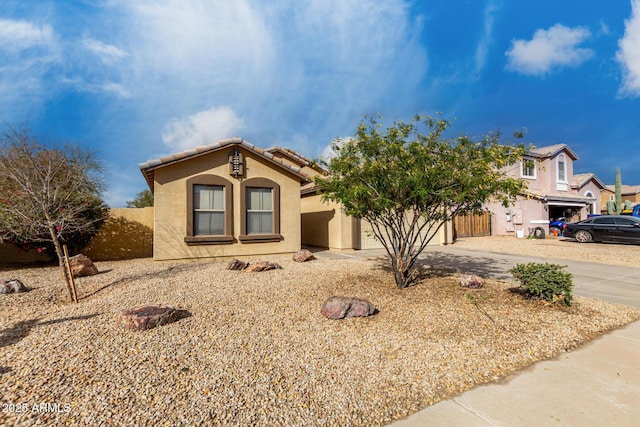 view of front of house with driveway, an attached garage, a tile roof, and stucco siding