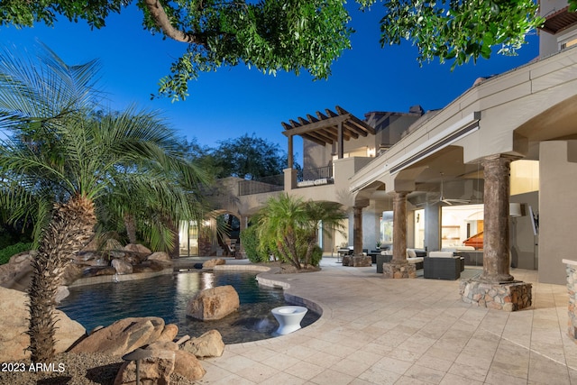 pool at night featuring a patio