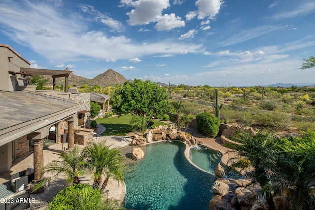 view of pool featuring pool water feature, a mountain view, and a patio area