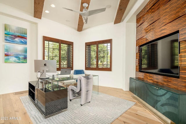 home office featuring ceiling fan, beamed ceiling, and light hardwood / wood-style floors