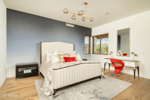 bedroom with a notable chandelier and light hardwood / wood-style floors