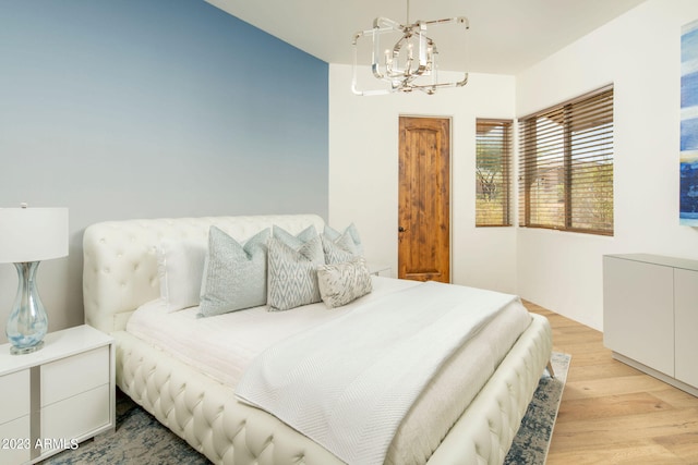 bedroom with a chandelier and light hardwood / wood-style floors