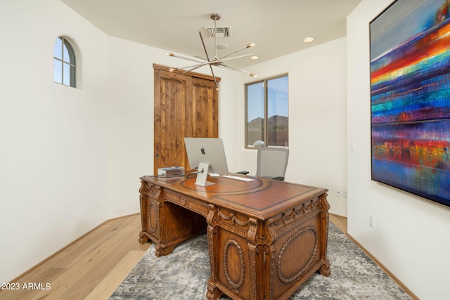 office area with an inviting chandelier, a wealth of natural light, and light hardwood / wood-style flooring