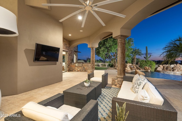 patio terrace at dusk with outdoor lounge area and ceiling fan