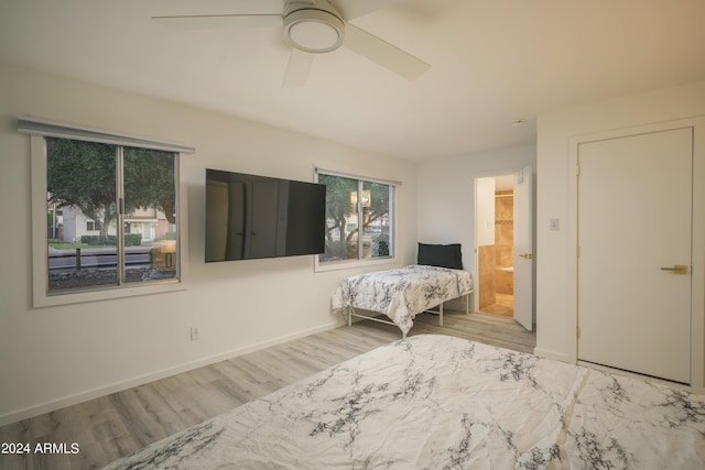 unfurnished bedroom featuring baseboards, ceiling fan, ensuite bath, and wood finished floors