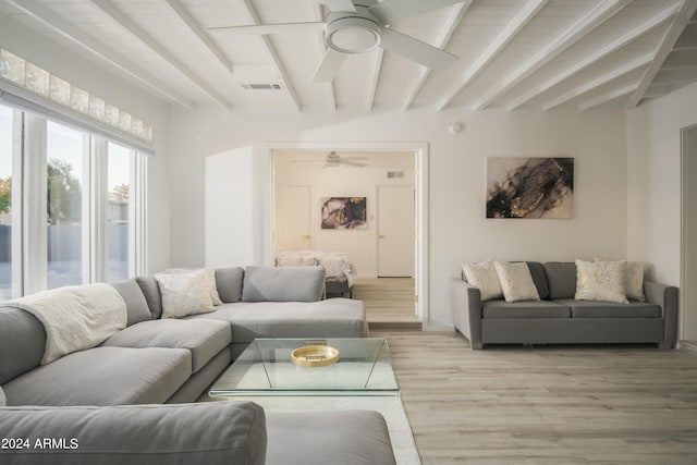 living area featuring a ceiling fan, beamed ceiling, visible vents, and light wood-style floors