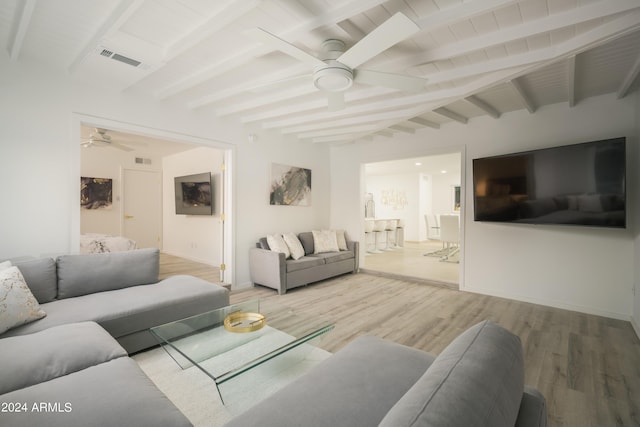 living area with a ceiling fan, visible vents, wood finished floors, and beamed ceiling